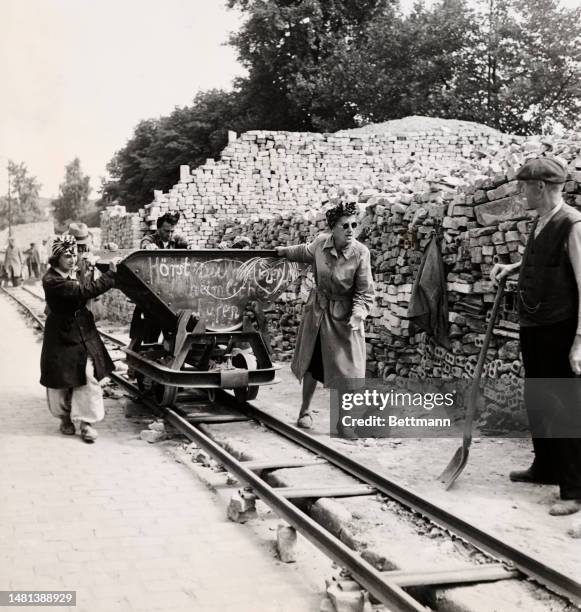 Three women pushing a coal trolley on a construction site in Berlin on August 5th, 1947.