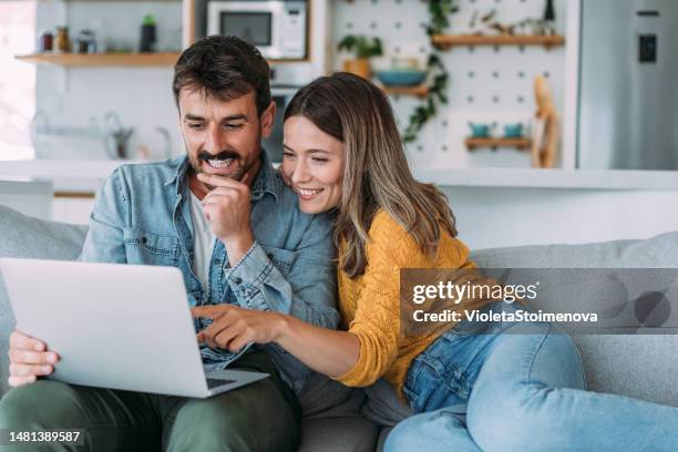 relajarse en casa con tecnología inalámbrica. - happy couple at home fotografías e imágenes de stock