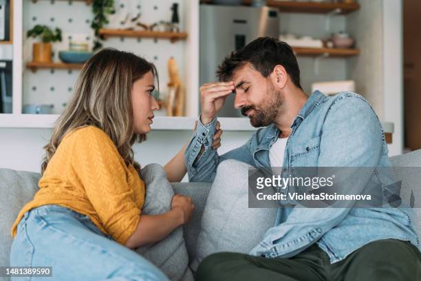 worried couple talking together in the living room at home. - couples 個照片及圖片檔