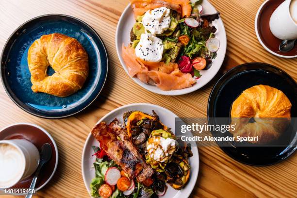 healthy breakfast with avocado toasts, poached eggs, salmon, croissants and cappuccino - porto portugal stockfoto's en -beelden