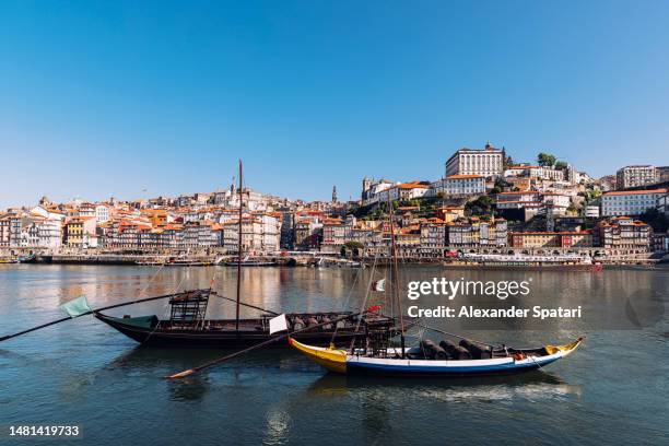 rabelo boats on douro river and porto skyline on a sunny day with clear blue sky, portugal - rabelo boat stock pictures, royalty-free photos & images