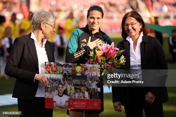 Dzsenifer Marozsan of Germany receives a bouquet of flowers after announcing their retirement form international football prior to the Women's...