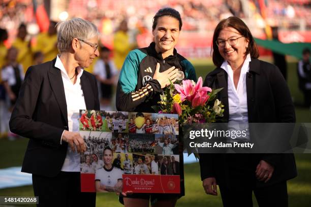 Dzsenifer Marozsan of Germany receives a bouquet of flowers after announcing their retirement form international football prior to the Women's...