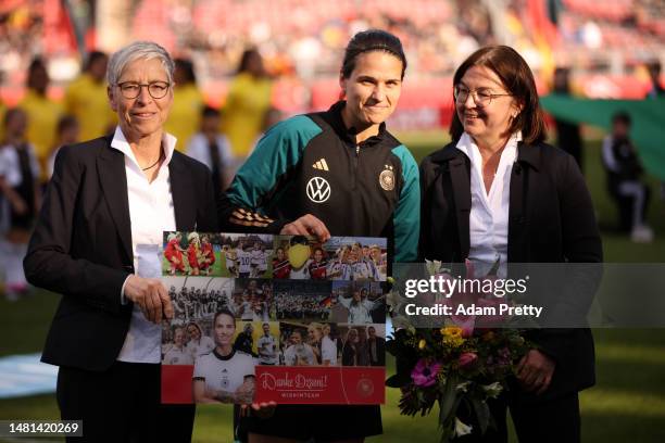 Dzsenifer Marozsan of Germany receives a bouquet of flowers after announcing their retirement form international football prior to the Women's...