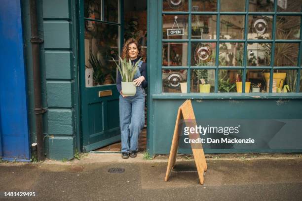 female small business owner outside plant shop - nailsworth gloucestershire stock pictures, royalty-free photos & images