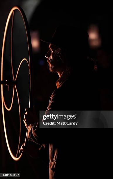 Performer watches as fires are lit near the ancient megalithic monument of Stonehenge during the Fire Garden as part of the Salisbury International...