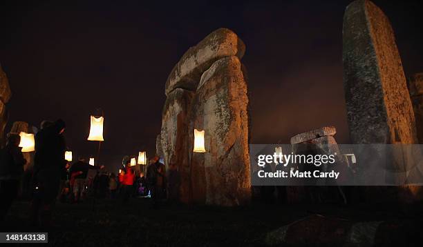 Visitors walk inside the ancient megalithic monument of Stonehenge as it is lit by fires during the Fire Garden as part of the Salisbury...