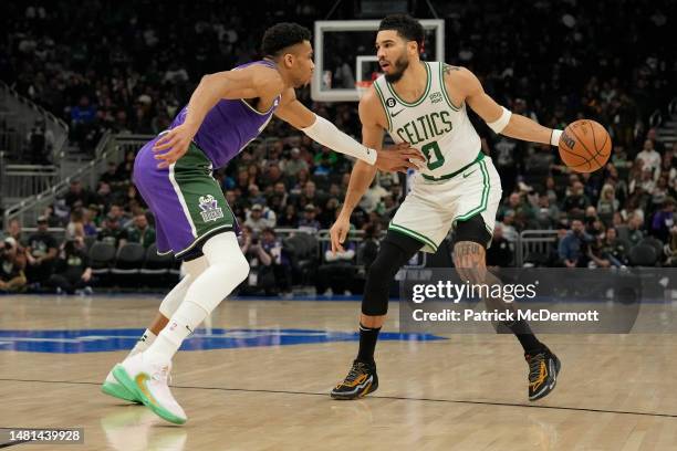 Jayson Tatum of the Boston Celtics dribbles the ball against Giannis Antetokounmpo of the Milwaukee Bucks in the second half at Fiserv Forum on March...