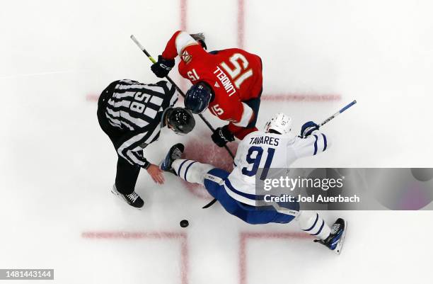 John Tavares of the Toronto Maple Leafs wins the face-off from Anton Lundell of the Florida Panthers after Linesman Ryan Gibbons drops the puck at...