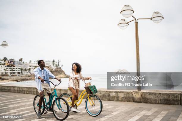 young couple during a bike ride on the coastline - mazatlan mexico stock pictures, royalty-free photos & images