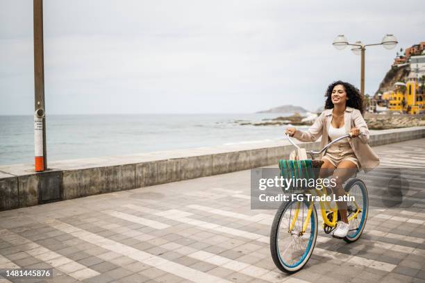 mujer joven usando una bicicleta en la costa - ciudadanos mexicanos fotografías e imágenes de stock