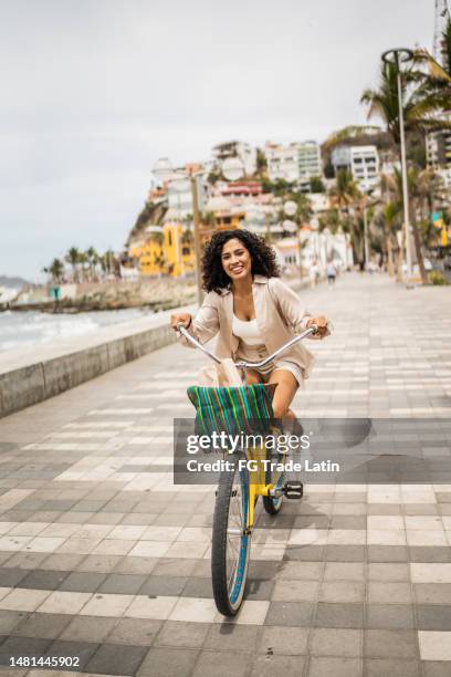 young woman using a bike on the seacoast - mazatlan stock pictures, royalty-free photos & images