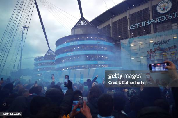 The Manchester City team bus arrives outside the stadium as fans cheer prior to the UEFA Champions League quarterfinal first leg match between...