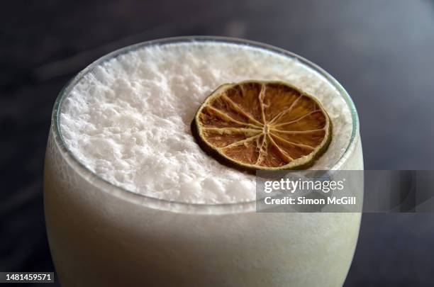 glass of limonada de coco [coconut limeade] made with lime juice, coconut cream, ice and sugar syrup, topped with a dehydrated lime slice - valle del cauca photos et images de collection