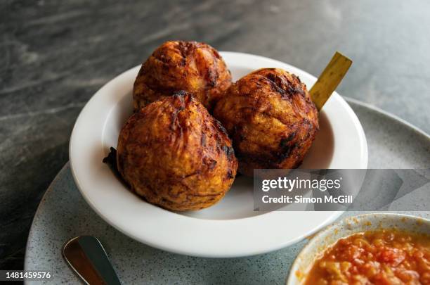 marranitas con hogao (green plantain fritters stuffed with crunchy pork and served with a colombian tomato relish sauce) - valle del cauca stock pictures, royalty-free photos & images