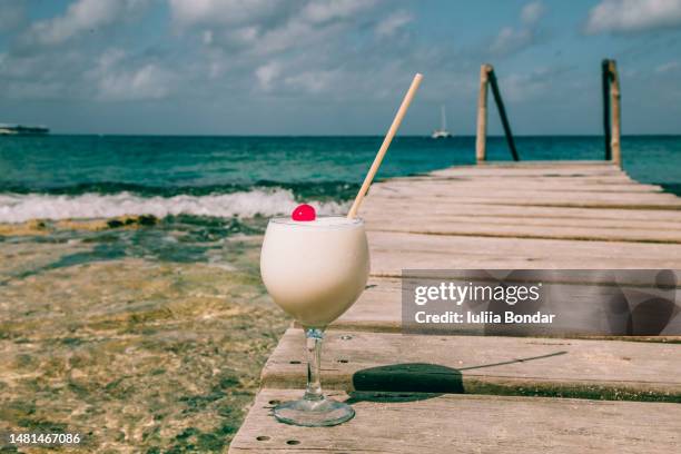 pina colada cocktail on a beach - pina colada stock pictures, royalty-free photos & images