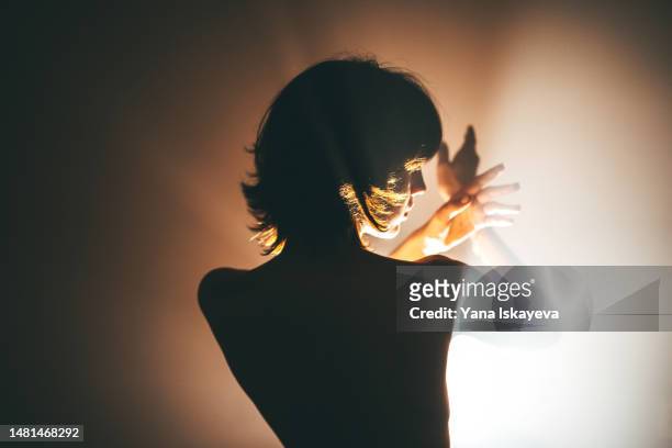 a beautiful asian young woman, a silhouette dancing in the room with cinematic lights - revelation stock pictures, royalty-free photos & images