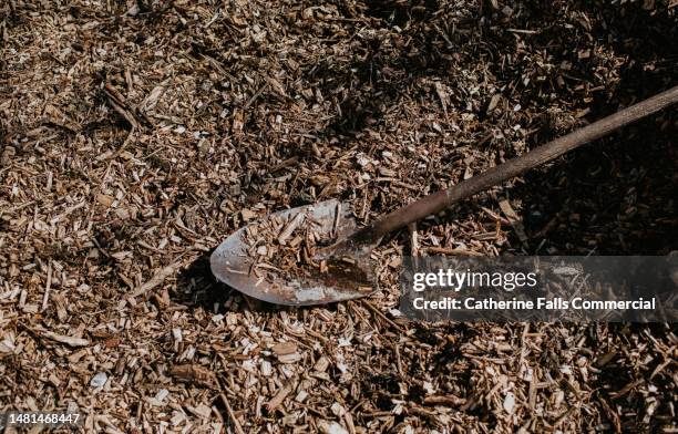 simple image of a spade among a pile of woodchips - cobertura do solo imagens e fotografias de stock