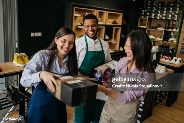 the saleswoman packs the shoes into a box - smart shoes stock pictures, royalty-free photos & images
