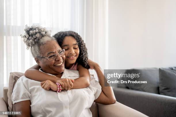 portrait d’une grand-mère et d’une petite-fille s’étreignant - famille avec des lunettes de vue photos et images de collection