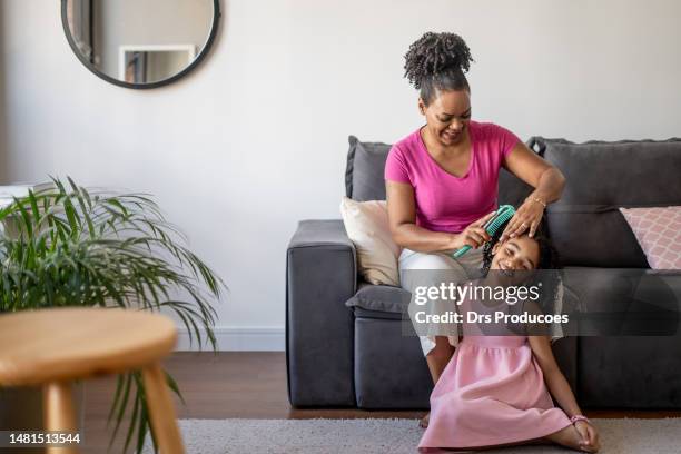 mother combing daughter's hair - woman combing her hair stock pictures, royalty-free photos & images
