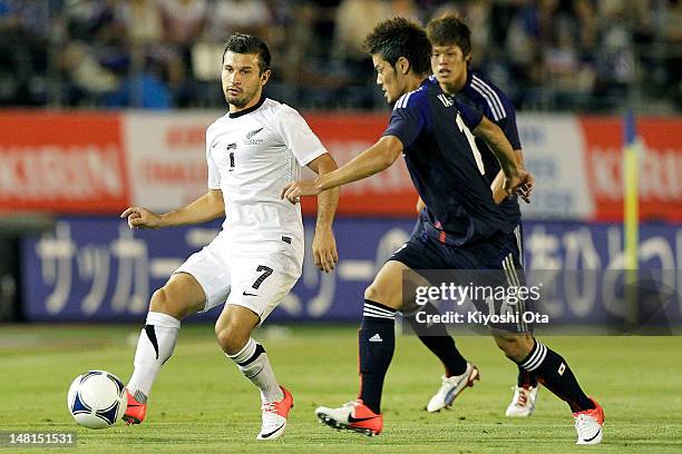 Kosta Barbarouses of New Zealand controls the ball against Hotaru Yamaguchi of Japan during the international friendly match between Japan U-23 and...