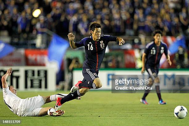Hotaru Yamaguchi of Japan is challenged by Adam McGeorge of New Zealand during the international friendly match between Japan U-23 and New Zealand...