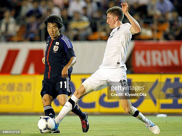 Kensuke Nagai of Japan and Adam Thomas of New Zealand contest the ball during the international friendly match between Japan U-23 and New Zealand...