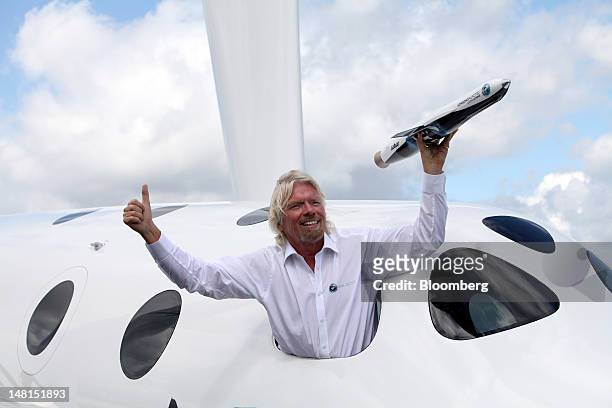 Richard Branson, poses for photographers with a model of the LauncherOne rocket, from the window of Virgin Galactic's SpaceShipTwo, on the third day...