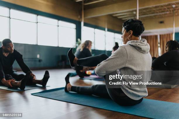 femme s’étirant pendant le cours de fitness - beautiful hips photos et images de collection