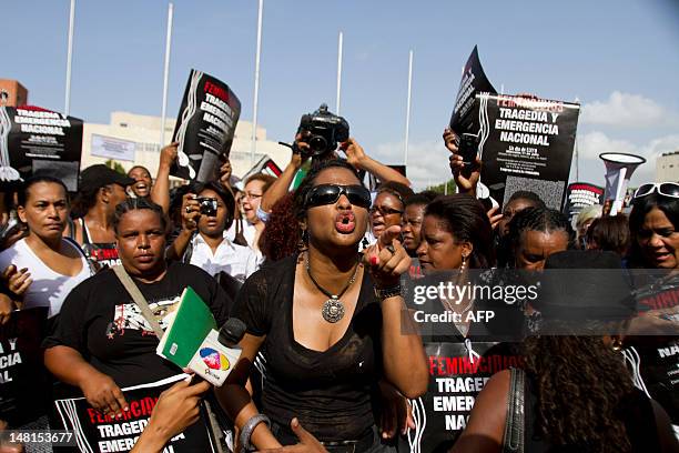 Dominican feminist activists hold placards as they protest against the murders of women, in front of the National Congress in Santo Domingo on July...