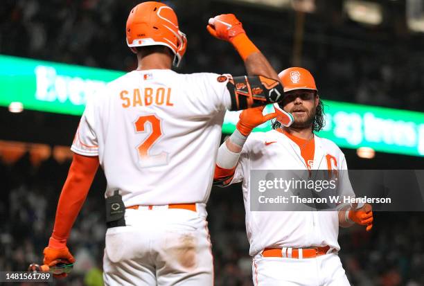 Brandon Crawford of the San Francisco Giants is congratulated by Blake Sabol after hitting a solo home run against the Los Angeles Dodgers in the...