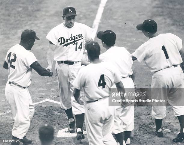Brooklyn Dodger Gil Hodges being congratulated after a homerun by Jackie Robinson, Pee Wee Reese and other teammates at Ebbets Field in Brooklyn, New...