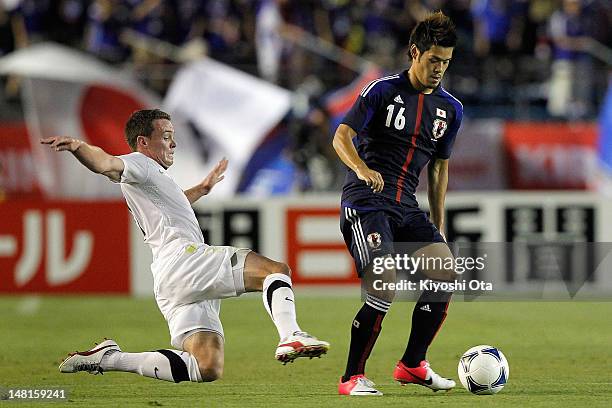 Hotaru Yamaguchi of Japan is challenged by Adam McGeorge of New Zealand during the international friendly match between Japan U-23 and New Zealand...