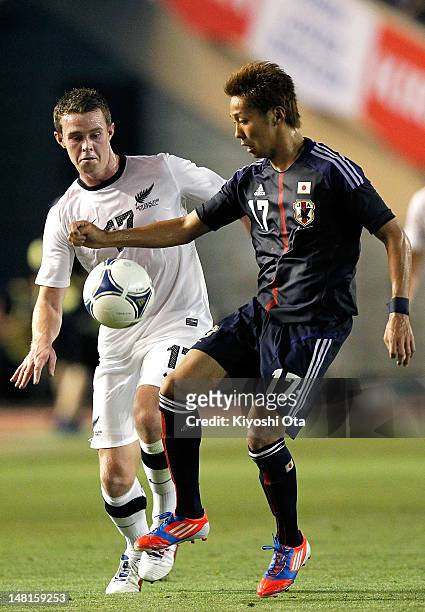 Hiroshi Kiyotake of Japan and Adam McGeorge of New Zealand compete for the ball during the international friendly match between Japan U-23 and New...