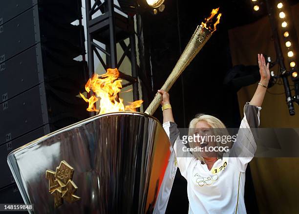 In this handout image provided by LOCOG, Torchbearer 120 Caroline Burnett lights the cauldron with the Olympic Flame after the Torch Relay leg...