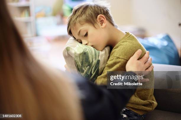 anxiety, bullying and hand of mother with boy hugging pillow for comfort, compassion and empathy at home. disability, abuse and mom with sad child suffering depression or mental health problem - sick child stockfoto's en -beelden