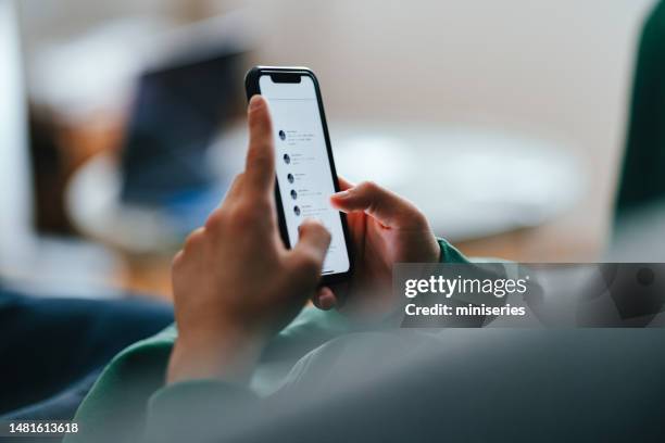 foto de cerca de manos adolescentes usando un teléfono móvil en casa - tweet fotografías e imágenes de stock