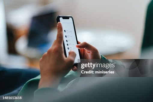Photo en gros plan de mains d’adolescents utilisant un téléphone portable à la maison Photo en gros plan de mains d’adolescents utilisant un téléphone portable à la maison