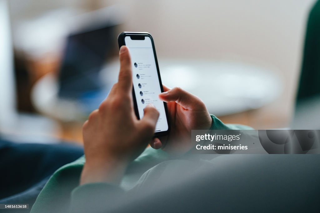 Close Up Photo Of Teenager Hands Using A Mobile Phone At Home