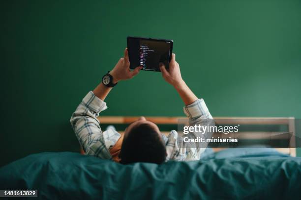 ein anonymer teenager, der ein digitales tablet in seinem schlafzimmer benutzt - tablet screen home stock-fotos und bilder