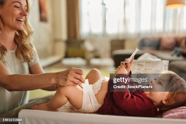 baby in bedroom getting diaper changed - nappy change stock pictures, royalty-free photos & images