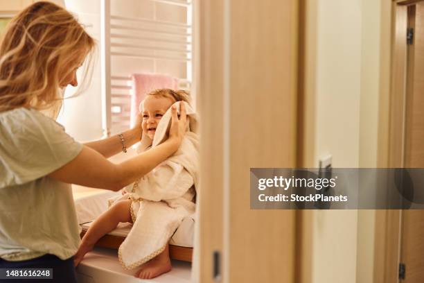 mother and baby girl after bath at home - baby in towel stock pictures, royalty-free photos & images