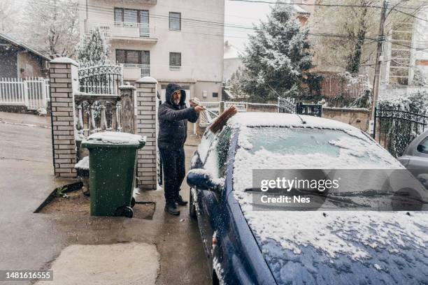 winter, ein mann reinigt den schnee vom auto - scraping stock-fotos und bilder