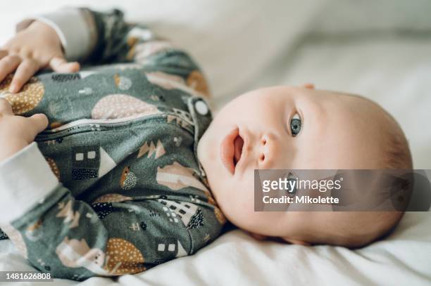 cute, relax and portrait of a baby on a bed for sleeping, relaxing or lying in a room. adorable, newborn and a child resting in the bedroom for comfort, relaxation and cozy in the morning at home - sleep hygiene stock pictures, royalty-free photos & images