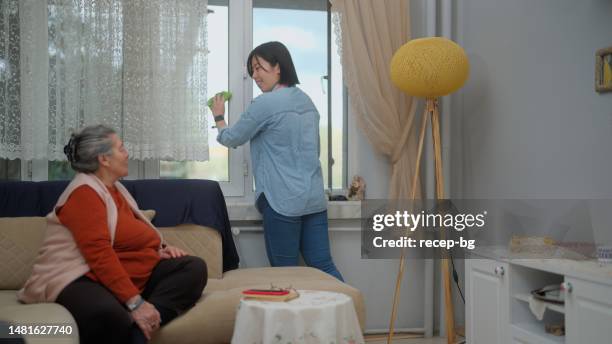 female care assistant cleaning senior woman’s house - poetshulp stockfoto's en -beelden