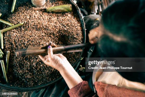 intha lady rolling a cigar in a cheroot manufacture of inle lake, myanmar - cheroot making stock pictures, royalty-free photos & images