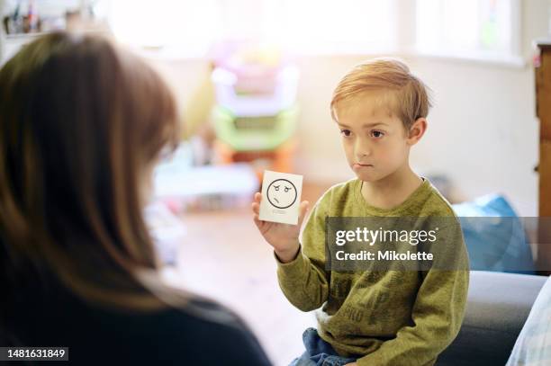 therapie, emotion und junge, der mit einem therapeuten spricht, während er auf einem sofa in einer psychologischen klinik sitzt. diskussion, karteikarte und kinderpsychologe, der einem kind mit seinen gefühlen, adhs und psychischer gesundheit hilft. - hysterie stock-fotos und bilder