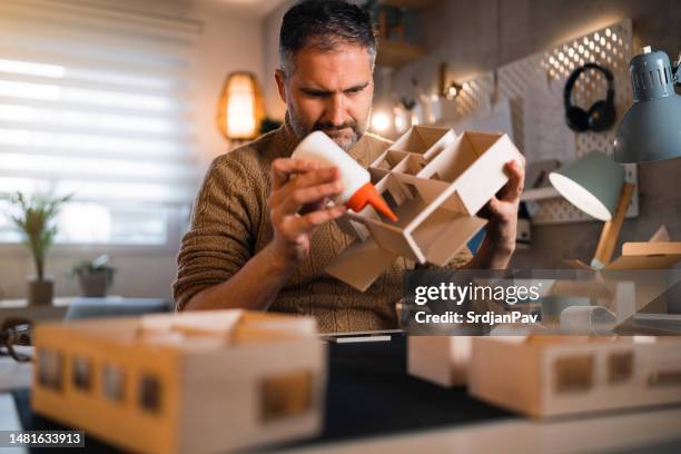 caucasian architect gluing architectural model - glue stock pictures, royalty-free photos & images