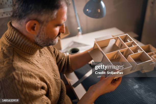 arquitecto caucásico observando el modelo arquitectónico que realiza - esterilla para cortar fotografías e imágenes de stock